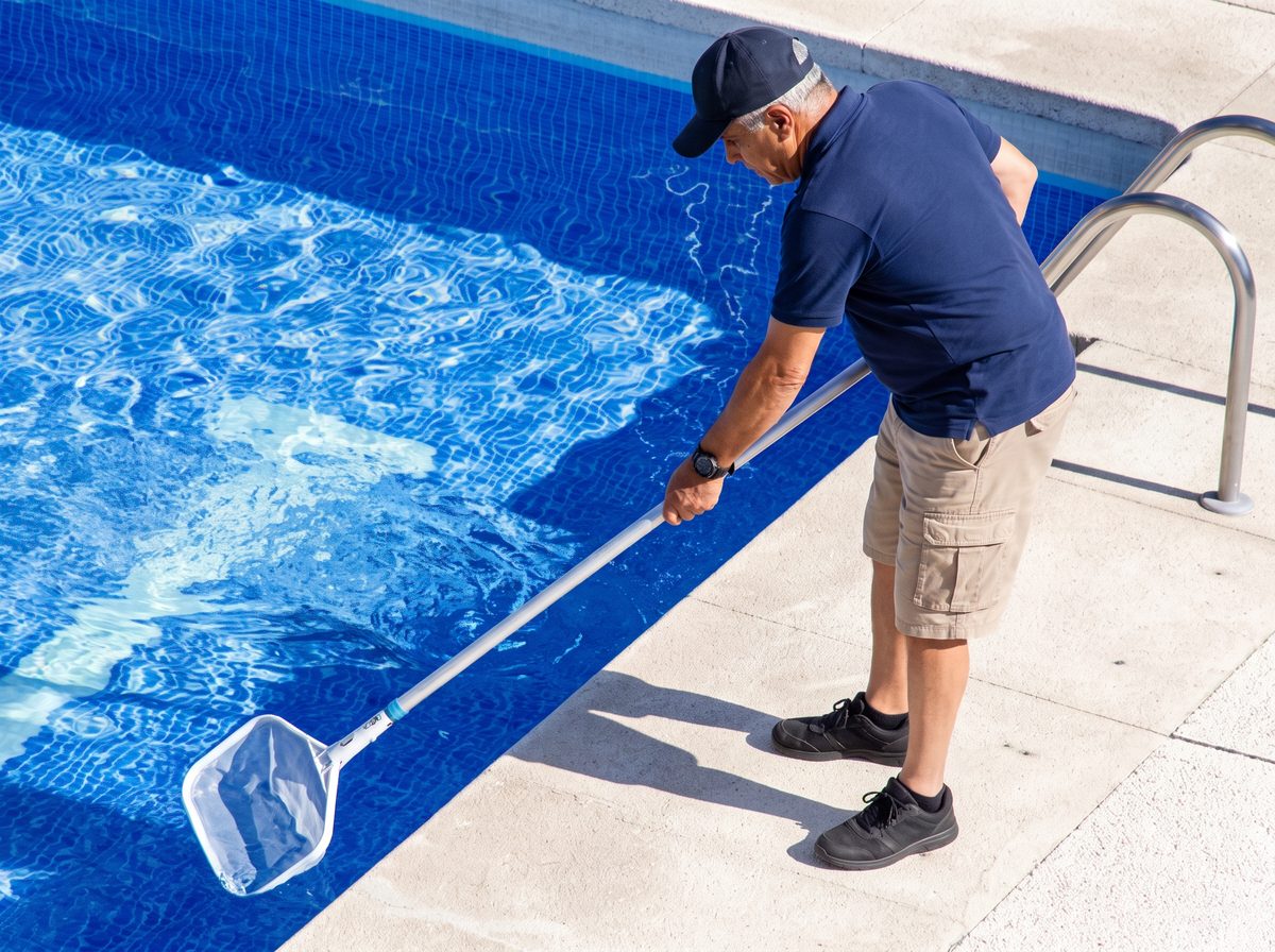 Robson limpando a piscina com a peneira