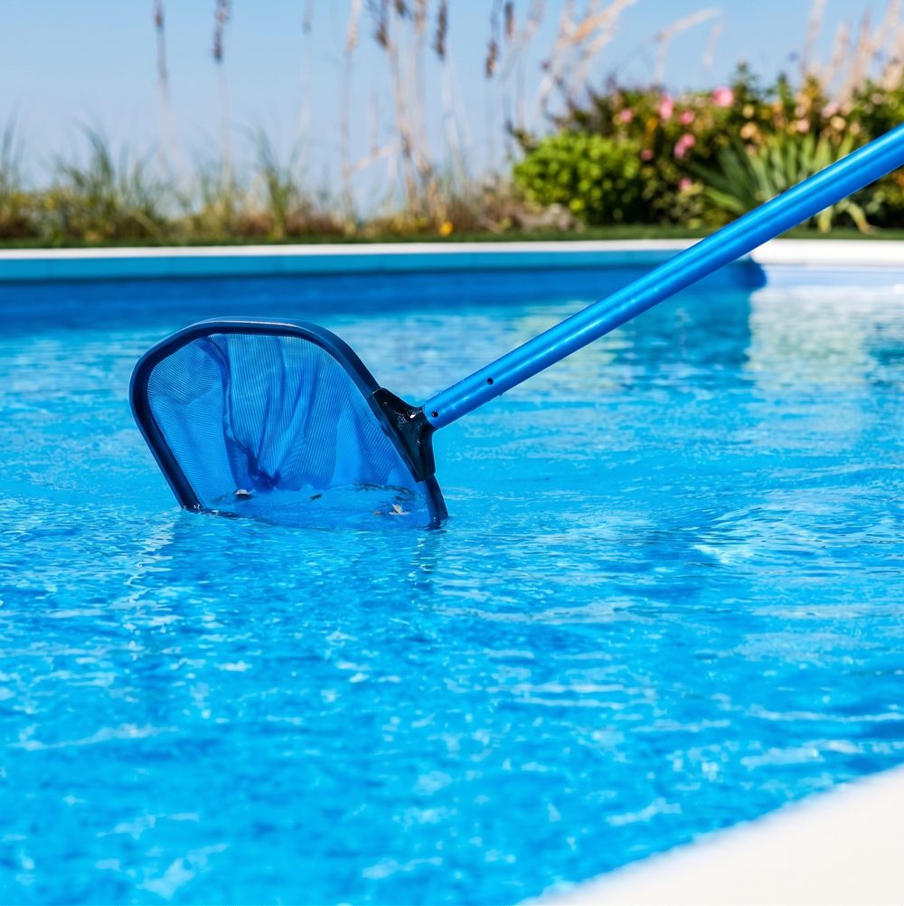 Peneira retirando sujeira da água da piscina